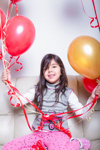 Low angle view of girl holding balloons
