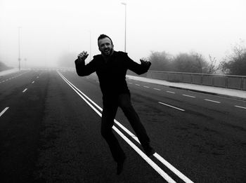 Full length of man skateboarding on road against sky