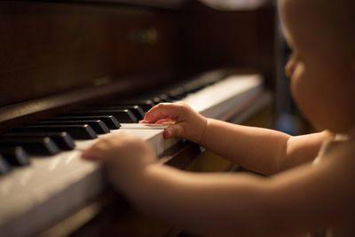 Close-up of toddler girl playing piano