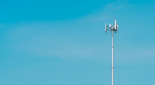 Low angle view of communications tower against blue sky