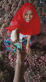 Smiling market vendor giving onions to customer