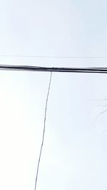 Low angle view of power lines against clear sky