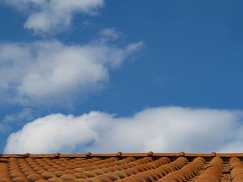 Low angle view of house roof against sky