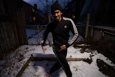 Young man standing in snow during winter