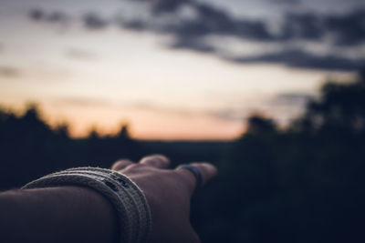 Cropped hand of person reaching sky