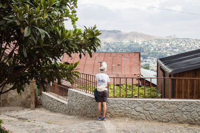 Rear view of woman with umbrella on water