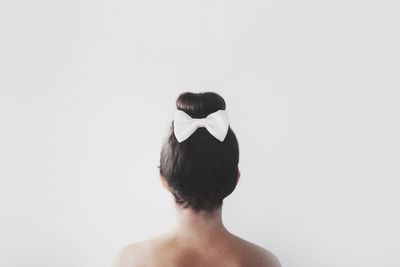 Rear view of shirtless woman against white background