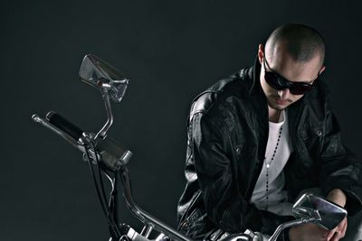 Man sitting on motorbike over black background