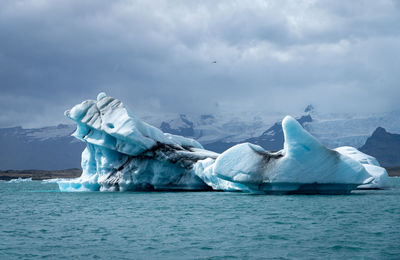 Scenic view of sea, glacier and mountains against sky