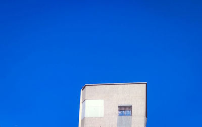 Low angle view of building against clear blue sky