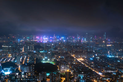 High angle view of illuminated city against sky at night