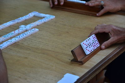 Cropped image of hands playing domino at table