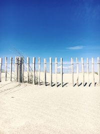 Text on beach against clear blue sky