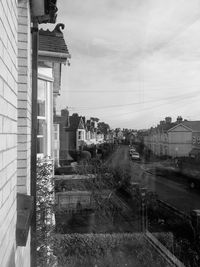 Road amidst row houses against sky seen from window glass