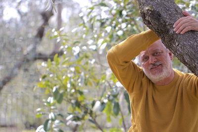 Low angle view of man holding tree