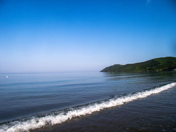 Scenic view of sea against clear blue sky