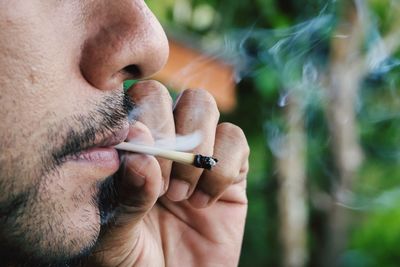 Close-up of man holding cigarette