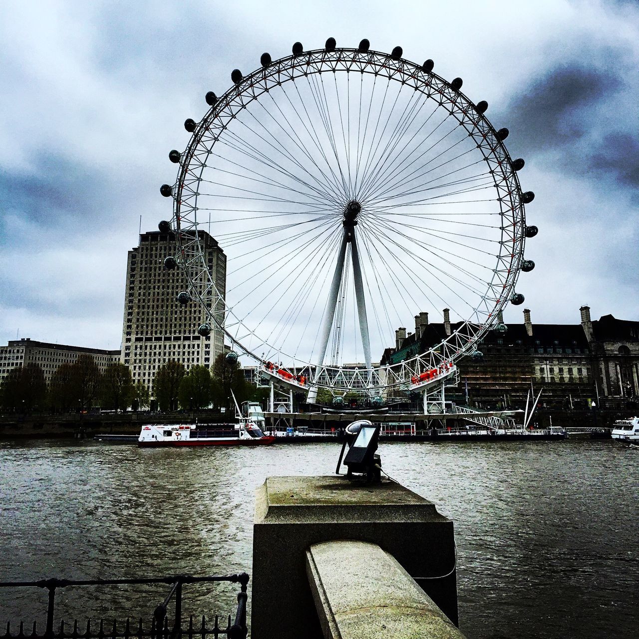 ferris wheel, amusement park ride, amusement park, architecture, built structure, arts culture and entertainment, sky, building exterior, travel destinations, city, cloud - sky, tourism, water, tall - high, famous place, international landmark, tower, travel, capital cities, millennium wheel