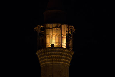 Low angle view of illuminated tower against sky at night