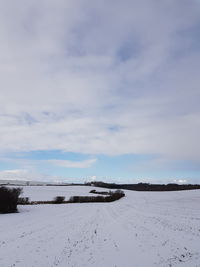 Snow covered land against sky