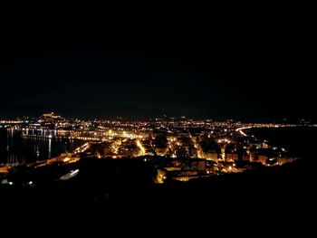 Illuminated cityscape against clear sky at night