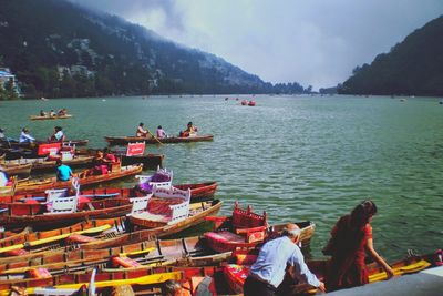 People in boat on lake against sky