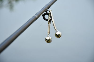 Low angle view of light bulbs hanging against sky