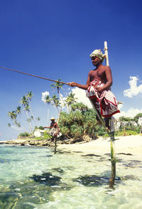 Fishermen stilt fishing in sea