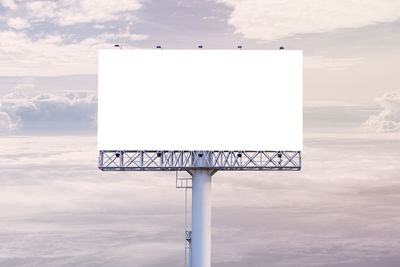 Information sign on pole against sky