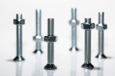 Close-up of bolts and nuts against white background