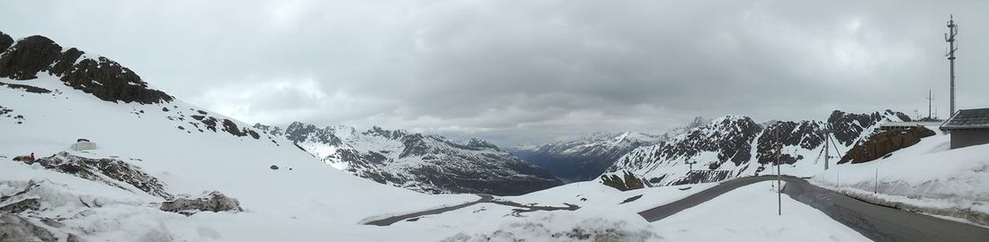 Scenic view of snow covered mountains against cloudy sky