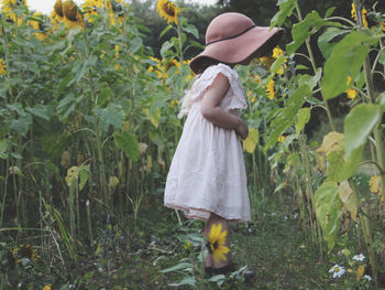 Rear view of woman standing amidst plants