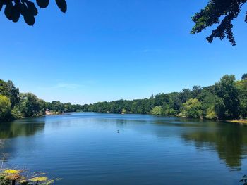 Scenic view of lake against clear blue sky