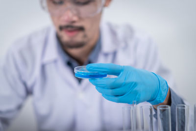 Midsection of man working in blue container