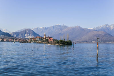 Scenic view of sea and mountains against clear blue sky