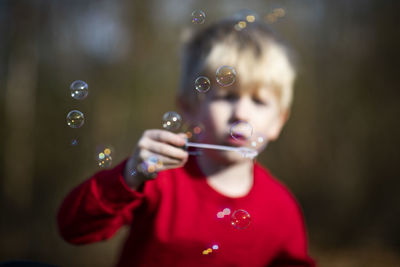 Boy playing with bubbles outdoors