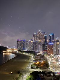 Illuminated buildings in city against sky at night