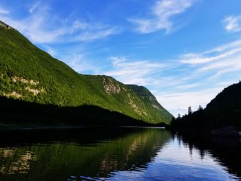 Scenic view of lake by mountains against sky