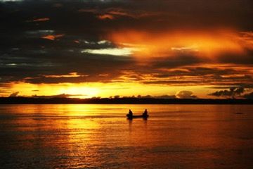 Silhouette people on sea against sky during sunset