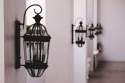 Close-up of electric lamp hanging against wall