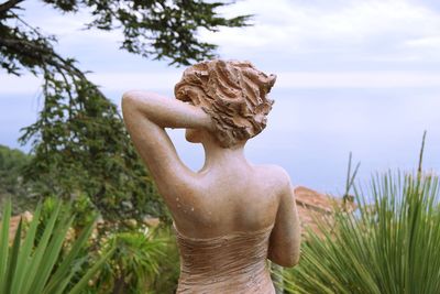 Statue amidst plants against sky