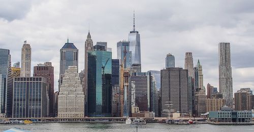 Modern buildings in city against cloudy sky