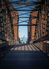 Footbridge over footpath amidst buildings in city