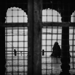 Silhouette people standing by window in building