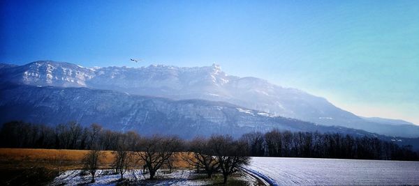 Scenic view of snowcapped mountains against blue sky