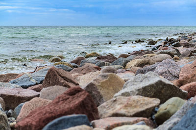 Close-up of rocks by sea against sky