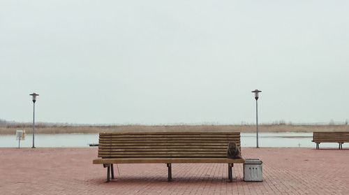 Empty benches against clear sky