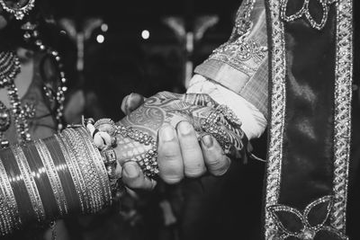 Midsection of newlywed couple holding hands