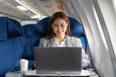 Businesswoman using laptop while sitting in car