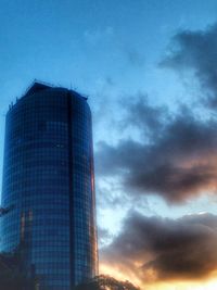 Low angle view of modern building against cloudy sky